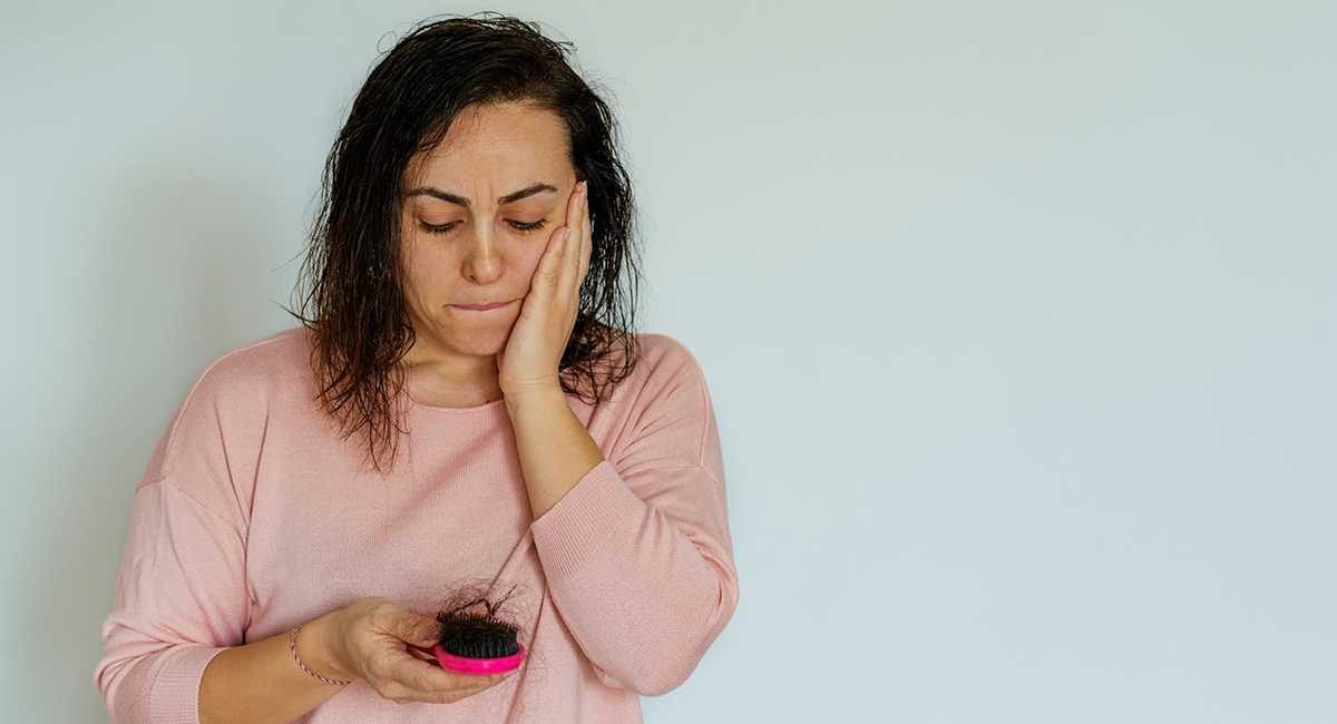 Mujer preocupada por caída del cabello