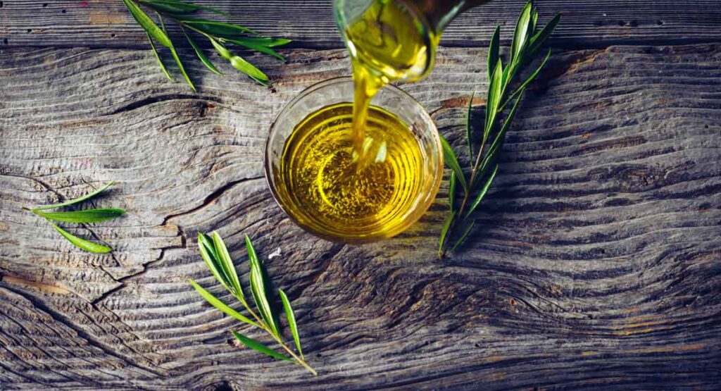 Botella de aceite de oliva con ramas de olivo