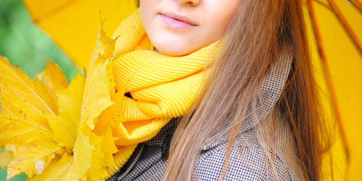 Beautiful young woman with a yellow umbrella